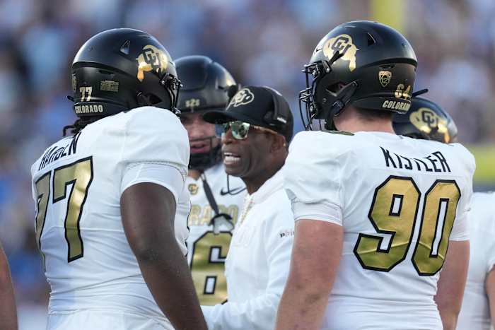 Colorado Buffaloes head coach Deion Sanders talks with offensive tackle Kareem Harden (77) in the first half against the UCLA Bruins at Rose Bowl